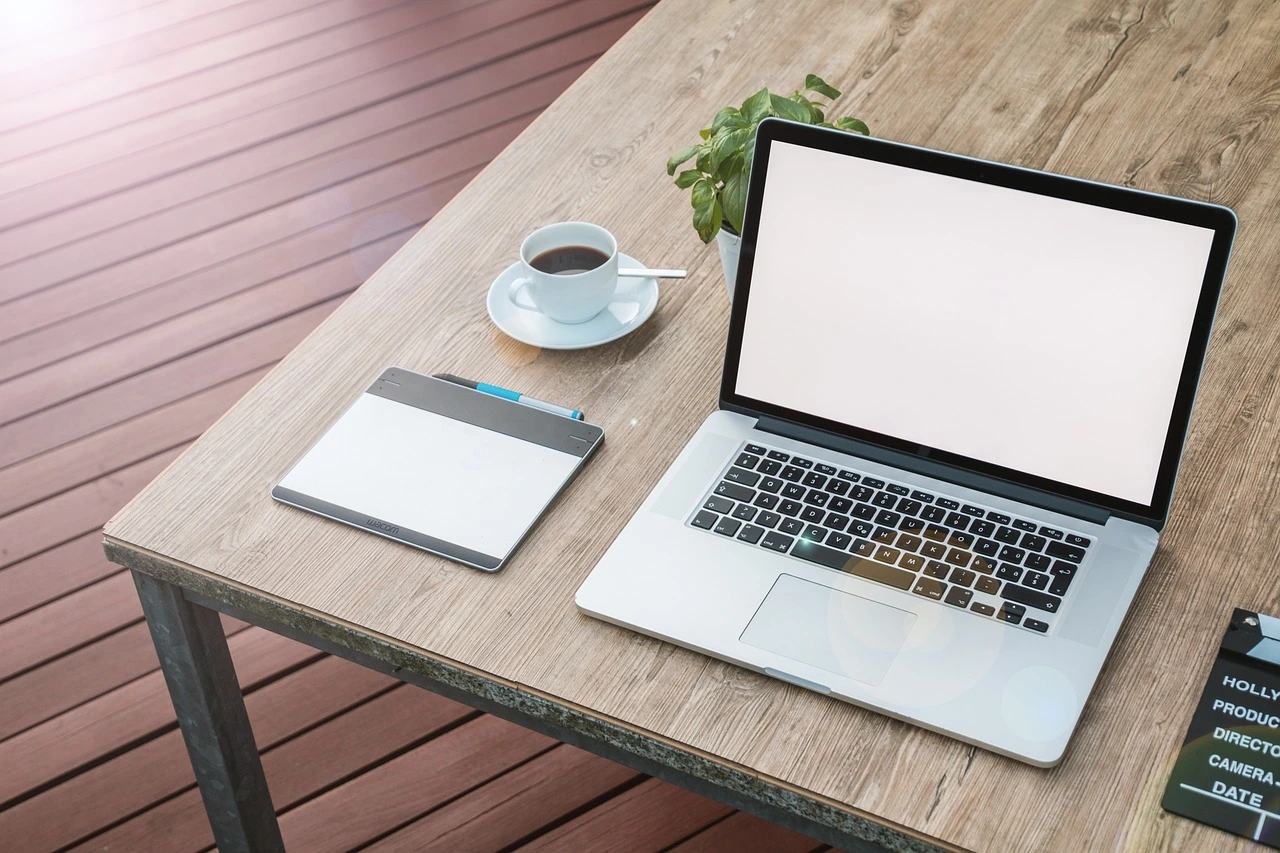 Ordinateur portable sur une table avec cahier et café